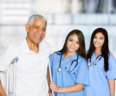 nurses and elderly man on crutches smiling