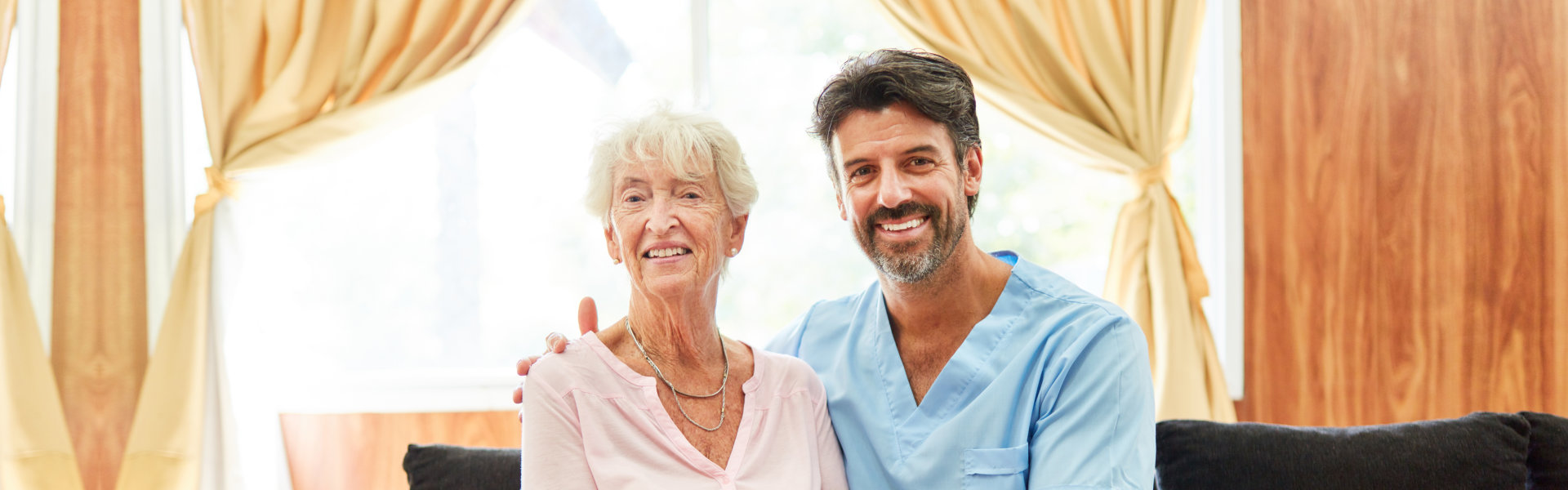 nurse and elderly woman looking at the camera